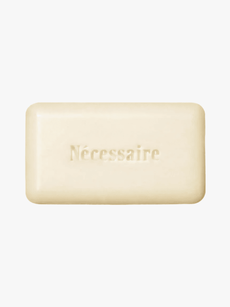 Nécessaire The Body Exfoliant Bar in branded component on a light gray background